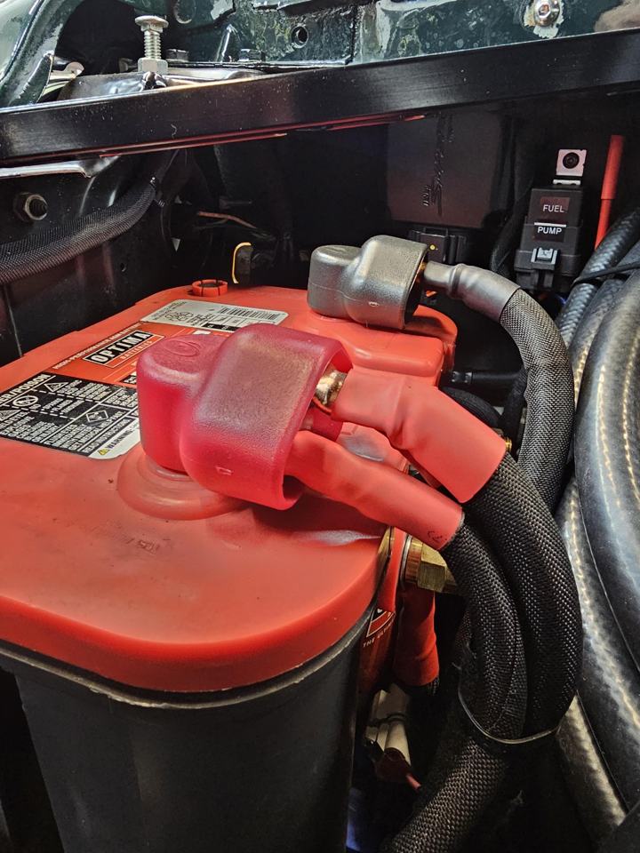 Optima battery with sleeved cables, terminal boots and a labeled fuel pump relay